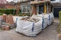 Bulk bags of builders rubble and bricks outside a house under renovation
