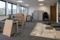 Open-plan office part-way through a strip-out with desks moved and carpet tiles lifted