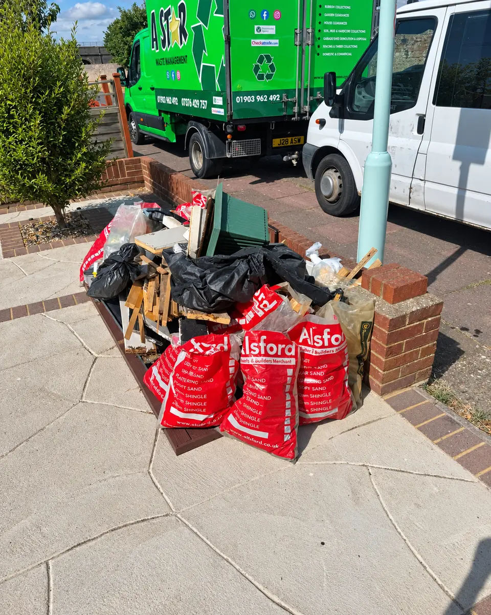 Before: red and black rubbish bags on a driveway with A Star vans parked behind