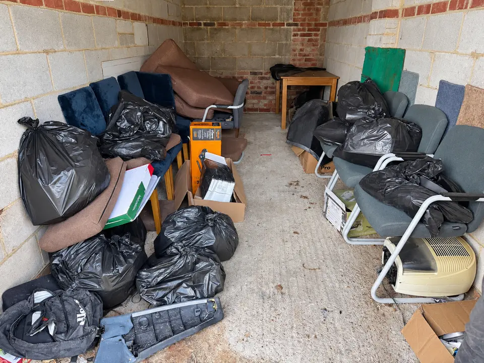 Before: a garage full of black bags, chairs and furniture