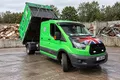 A Star tipper van with its body raised while unloading at a waste recycling yard