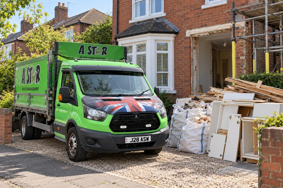 A Star tipper van next to bagged rubble, timber offcuts and renovation waste