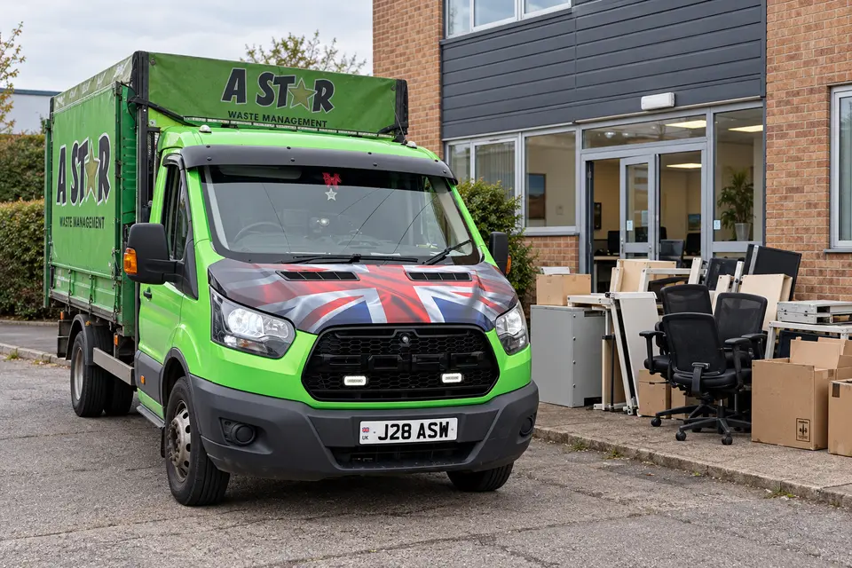 A Star van outside an office building with desks and chairs lined up for clearance